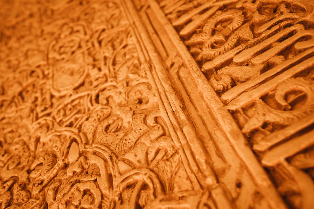 Detailaufnahme kunstvoller maurischer Inschriften in der Alhambra in Granada.