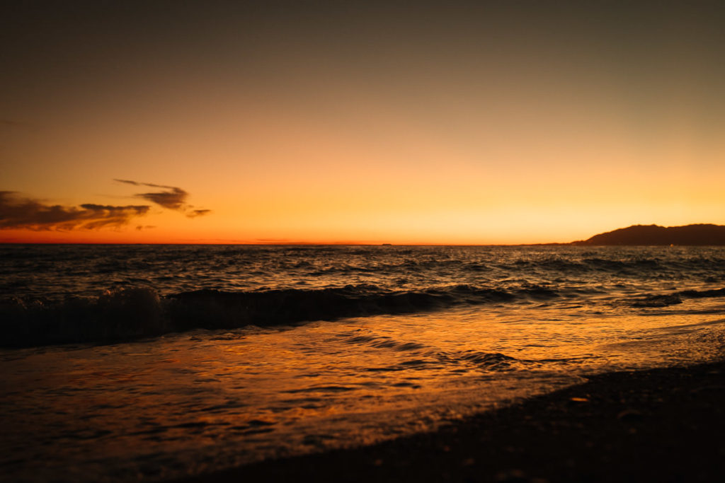 Die Sonne taucht ins Meer nahe Málaga in Rincón de la Victoria.