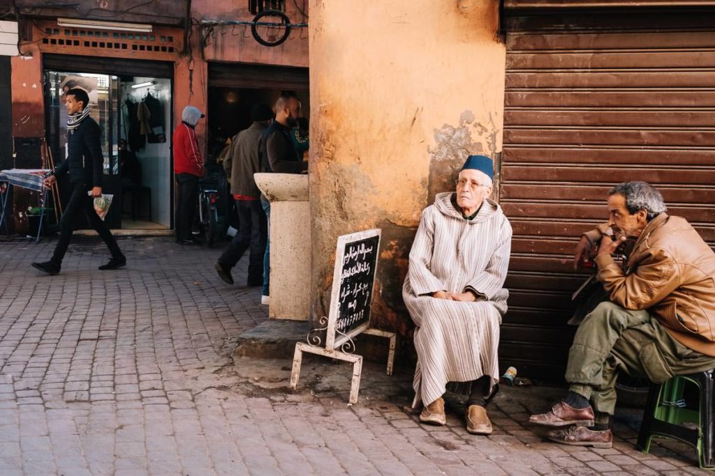 Am Rande des Souks in Marrakesch. Zwei Männer unterhalten sich.