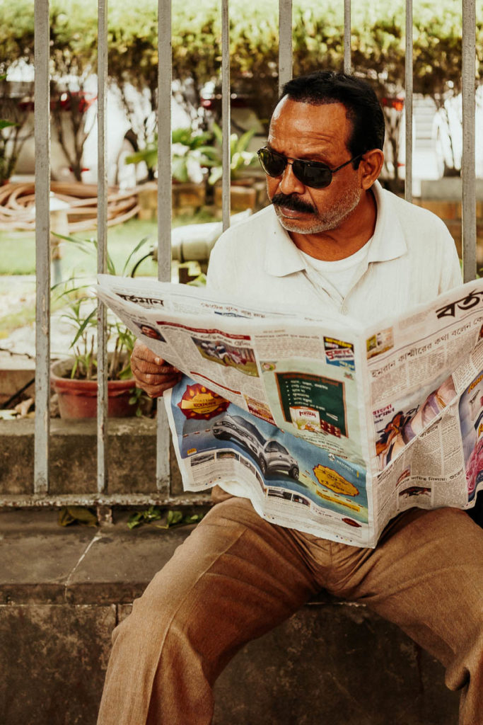 Mann liest Zeitung auf der Straße, Sightseeing in Kolkata mal anders.