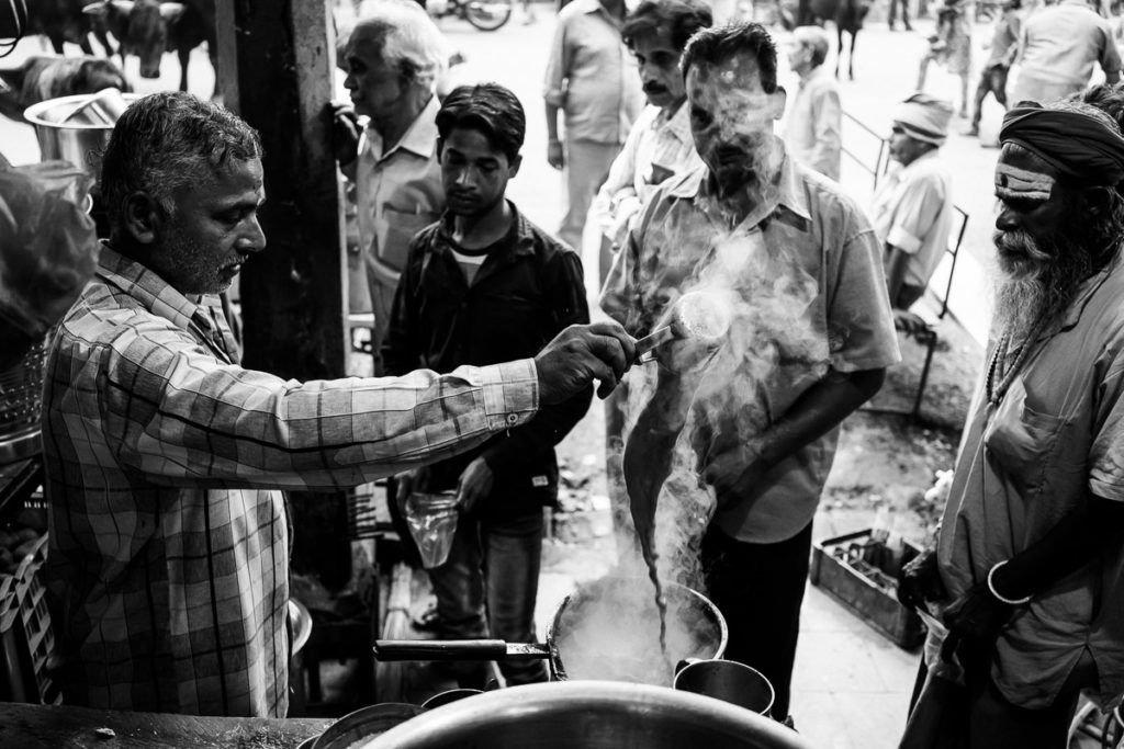 Indischer Chai, der Masala Chai in Varanasi. Der Tee wird mit Milch ständig kunstvoll umgewälzt.