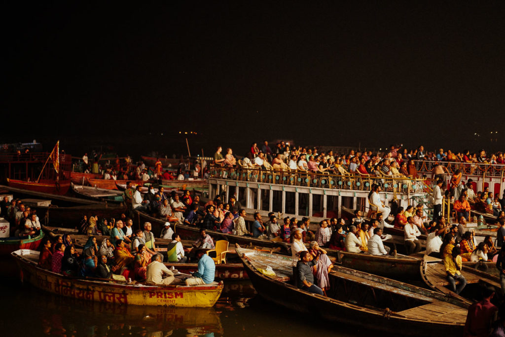 Viele Menschen versammeln sich am Ganges, um dem Aarti Ritual am Ghat in Varanasi beizuwohnen.