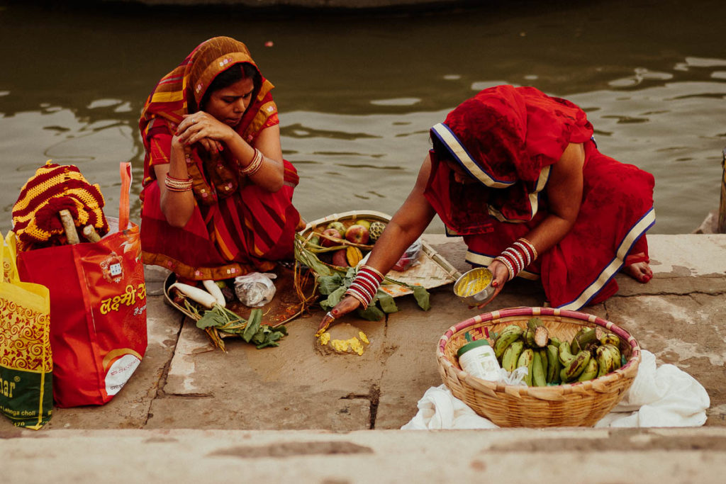 Zwei Frauen begehen ihr familiäres Ritual am Festtag Chhath Puja am Ufer des Ganges in Varanasi.