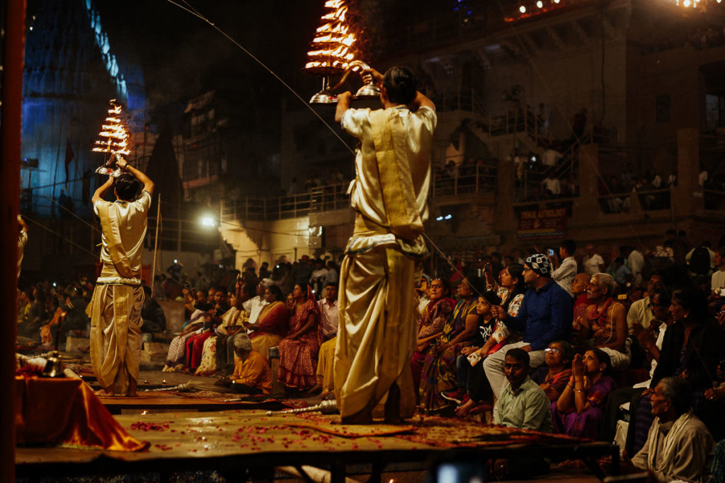 Religionsgelehrte schwenken große Feuerlampen während des Aarti Rituals in Varanasi.