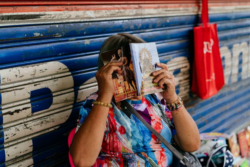 Frau versteckt sich hinter ihrem Buch