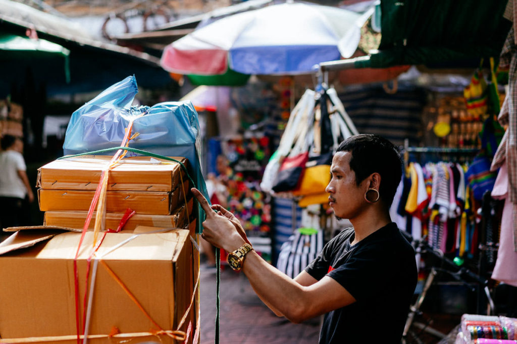 Mann drapiert Waren auf seinem Motorrad