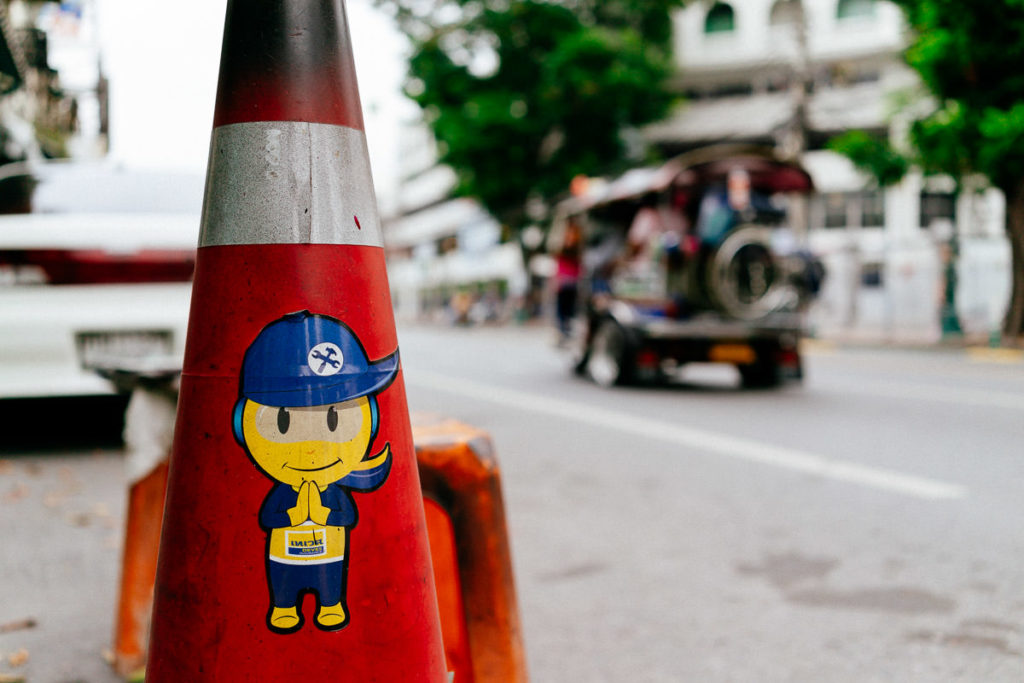 Ein Verkehrshütchen mit einem Sticker von einem Bauarbeiter verziert