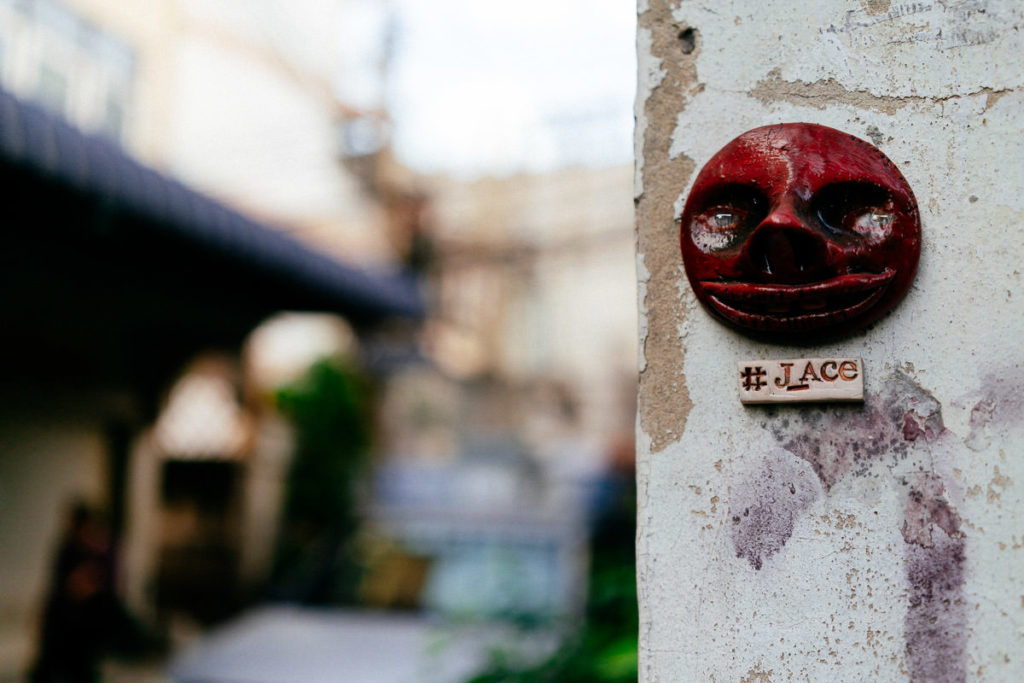 Rotes Gesicht aus Ton an einer Wand