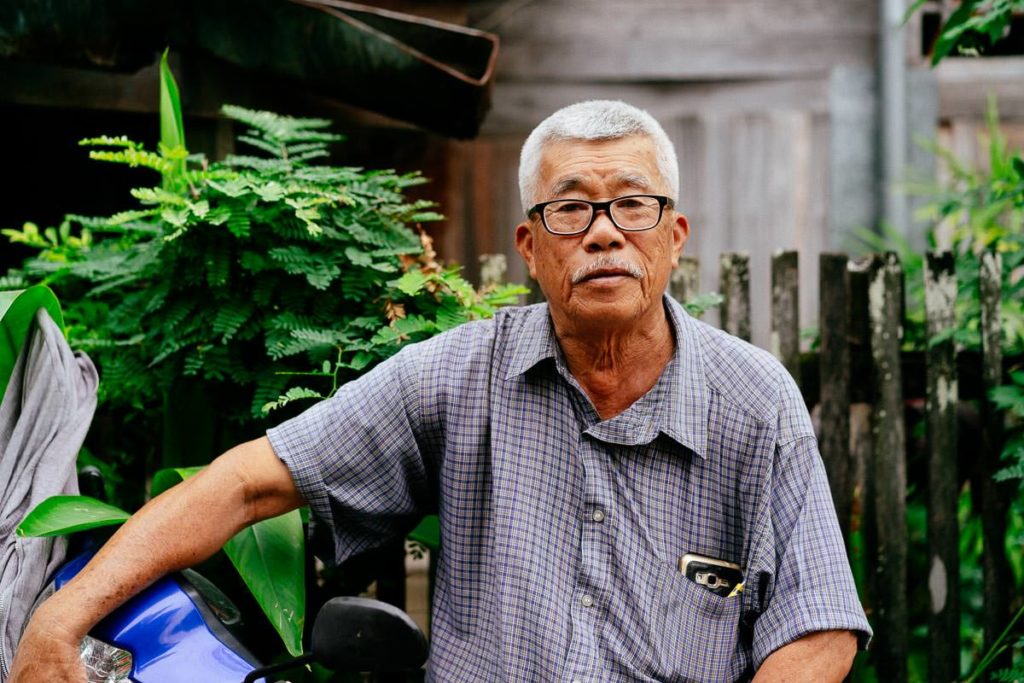 Mann mit seinem Moped in einer Nebenstraße in Chiang Mai