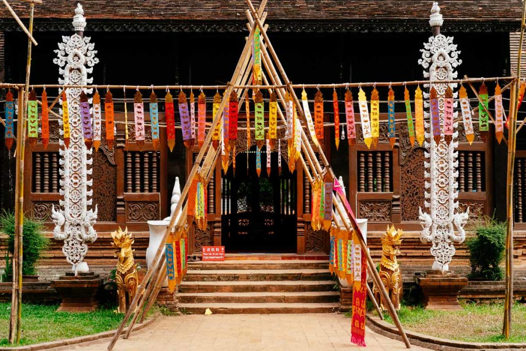 Mit Fähnchen verzierter Eingang zum Gebetsraum des Wat Lok Molei