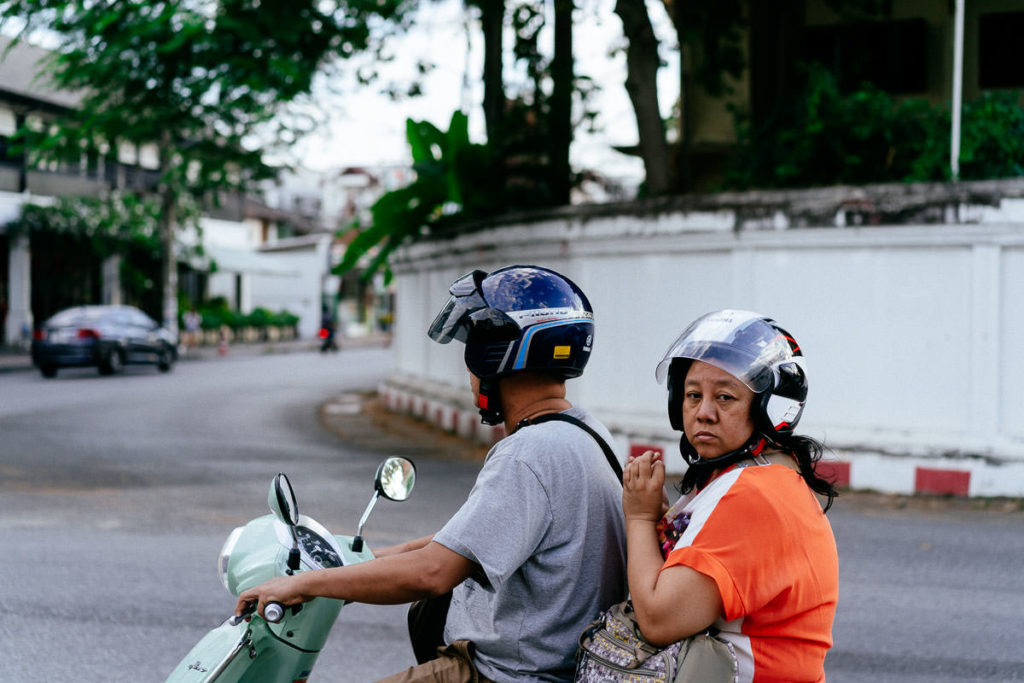 Typische Straßenszene: Mann und Frau auf Roller auf ihrem Weg