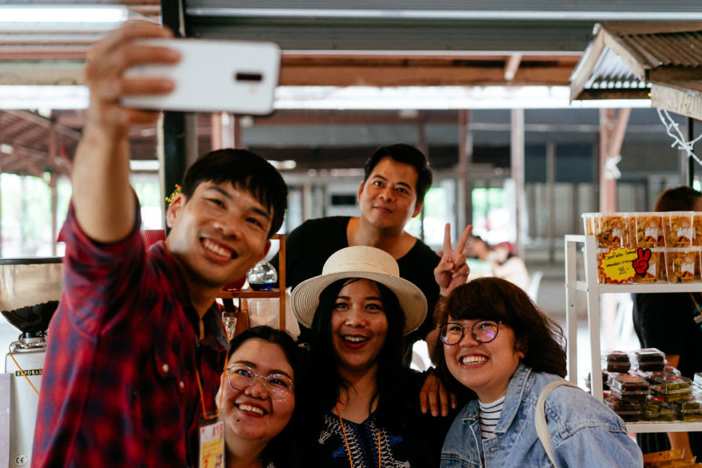Eine Gruppe von Besuchern und Ausstellern machen ein Selfie auf dem Chiang Mai Coffee Festival