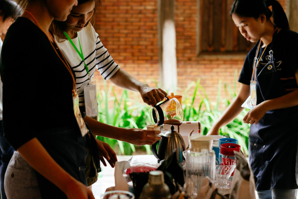 Eine Frau gießt Kaffee aus einer Kanne in eine Tasse